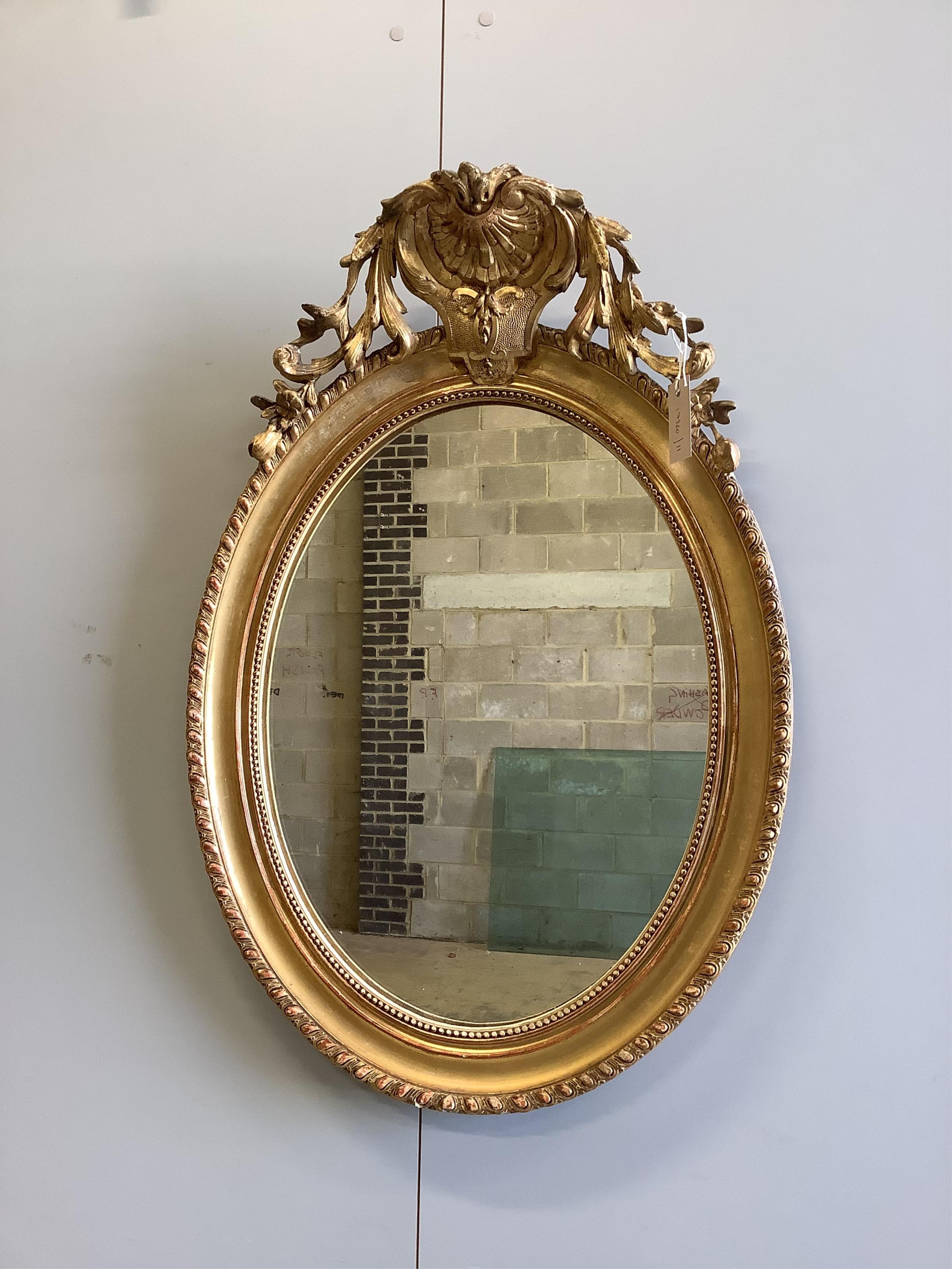 A 19th century French oval giltwood and composition wall mirror, width 57cm, height 80cm. Condition - good